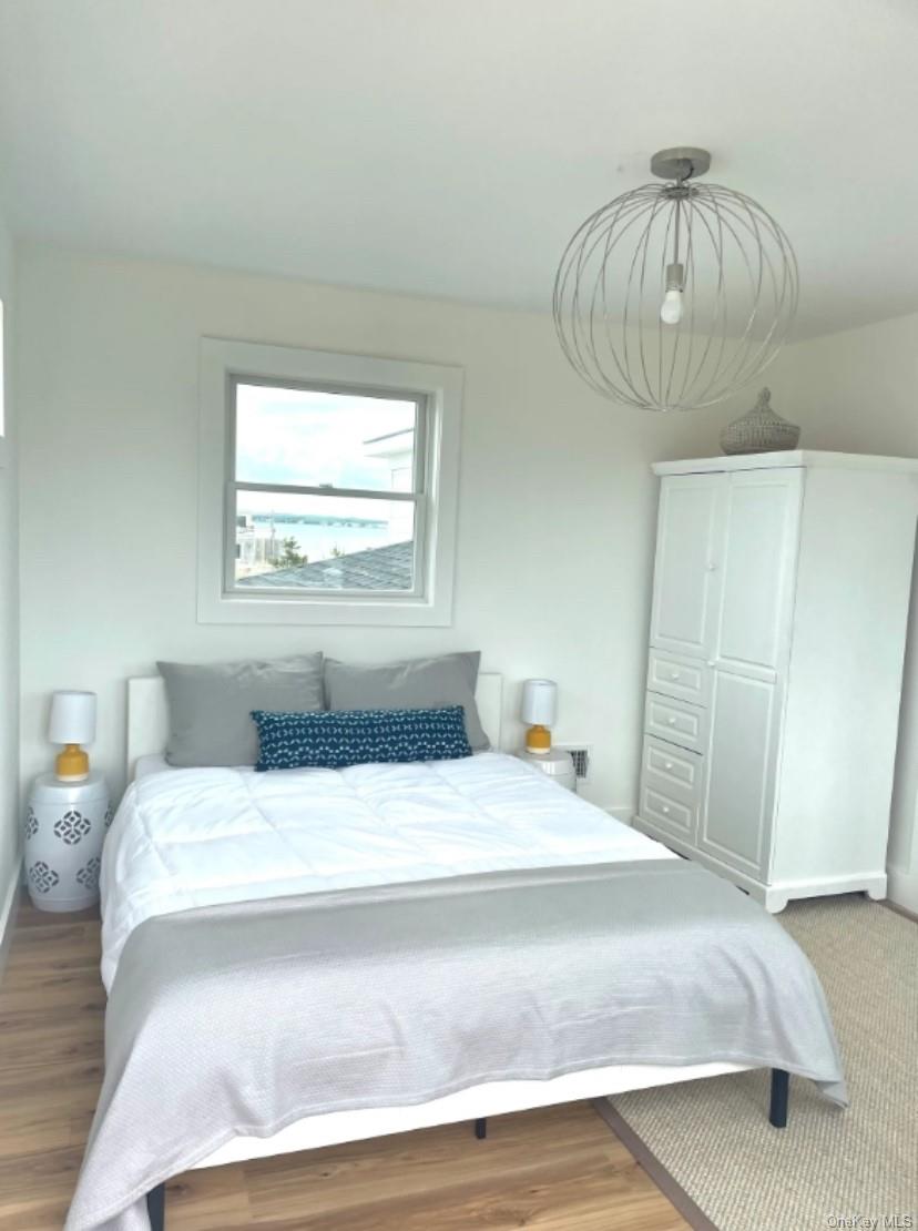 800 Dune Road Westhampton Beach, NY 11978 - Photo 8 of 19 a bedroom with a bed and a chandelier
