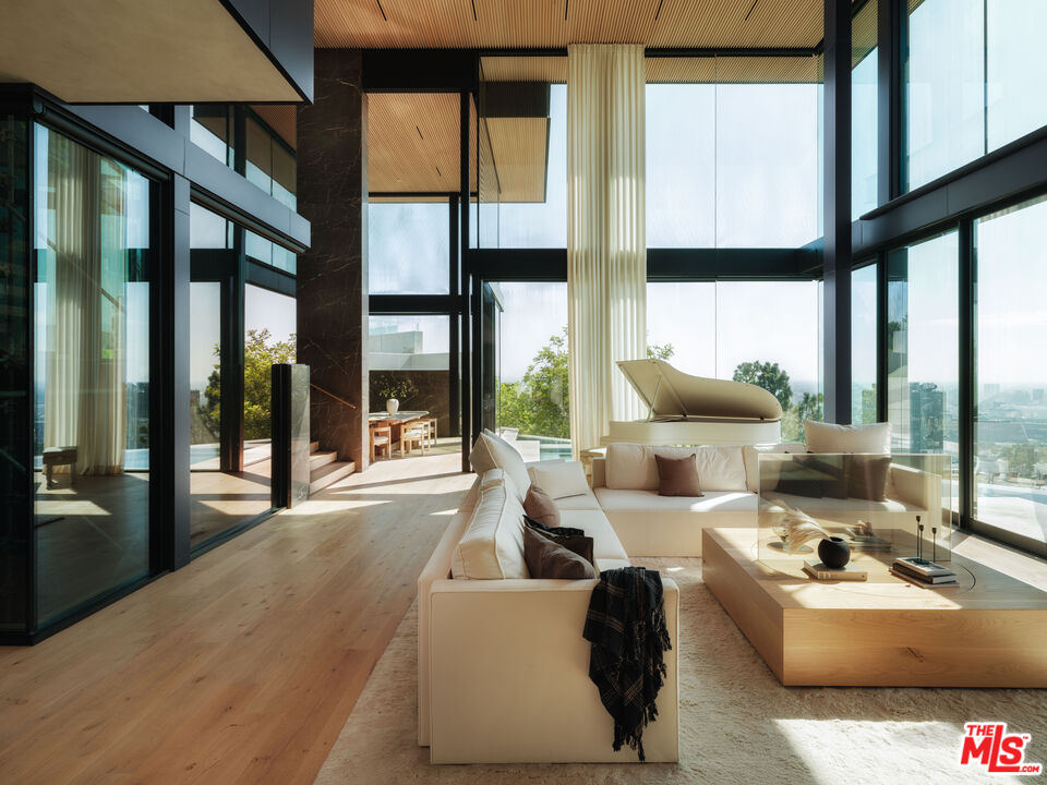 9126 Cordell Drive Los Angeles, CA 90069 - Photo 3 of 27 a living room with large windows a couch and chairs