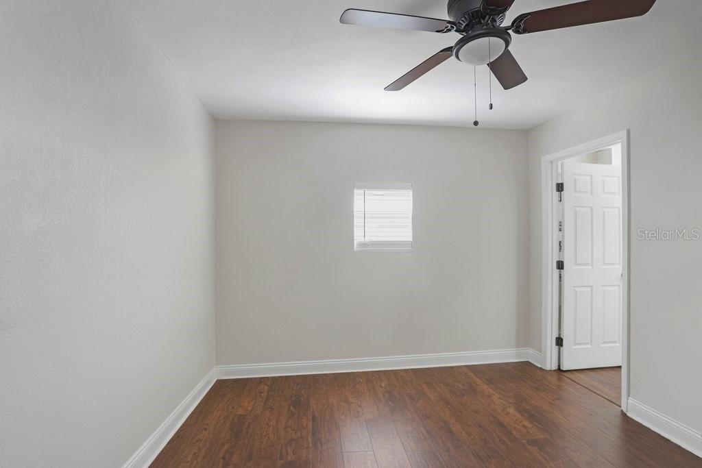 903 North Park Road Plant City, FL 33563 - Photo 12 of 28 an empty room with wooden floor ceiling fan and windows