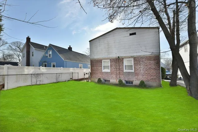 a view of a yard in front of a house with a large tree