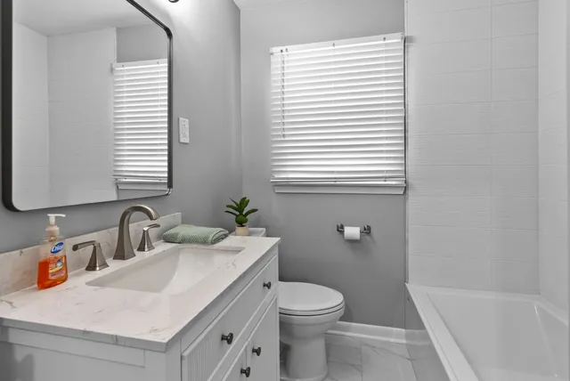 a bathroom with a sink a toilet and a window