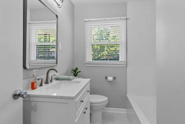 a bathroom with a toilet sink and mirror