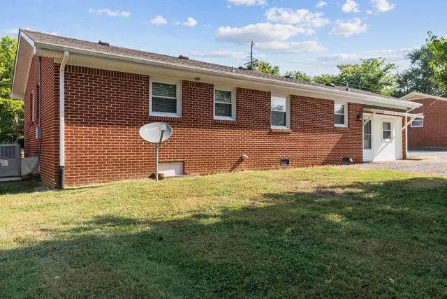 a front view of a house with a yard and tree