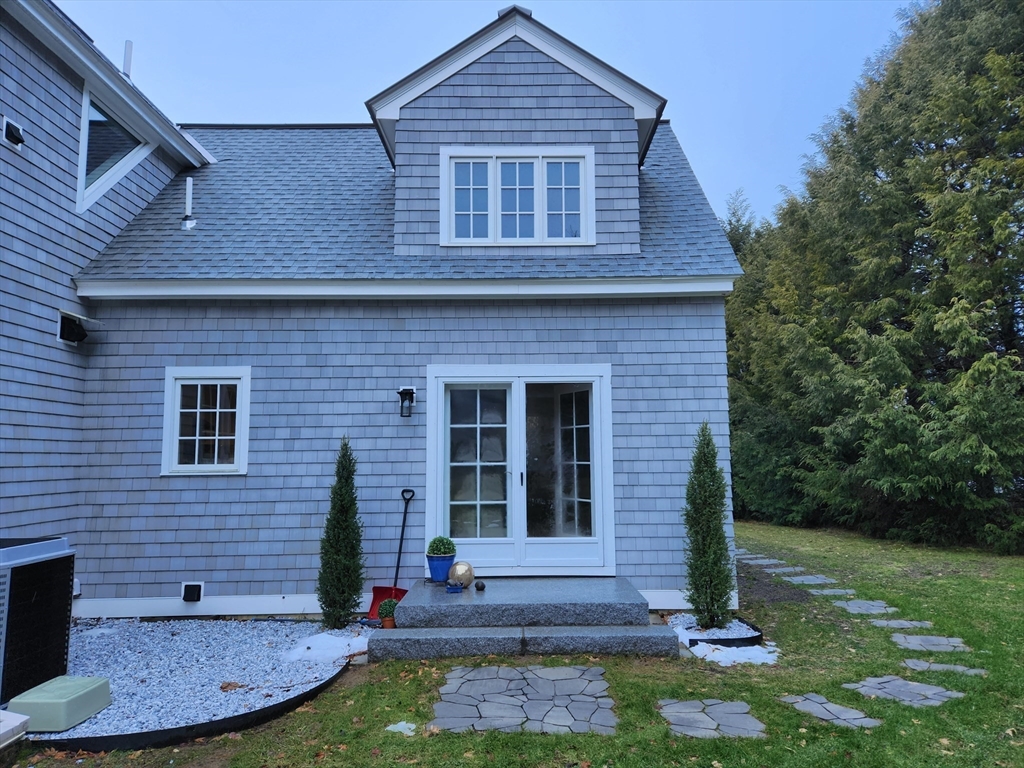 11 Low Street, Unit 1 Newbury, MA 01951 - Photo 14 of 14 a view of a brick house with a yard potted plants and large tree