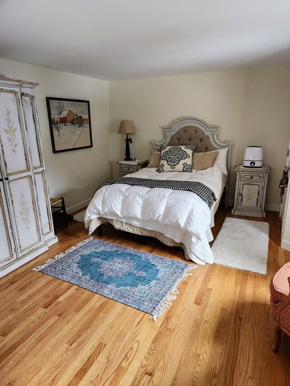 11 Low Street, Unit 1 Newbury, MA 01951 - Photo 8 of 14 a bedroom with a bed and wooden floor