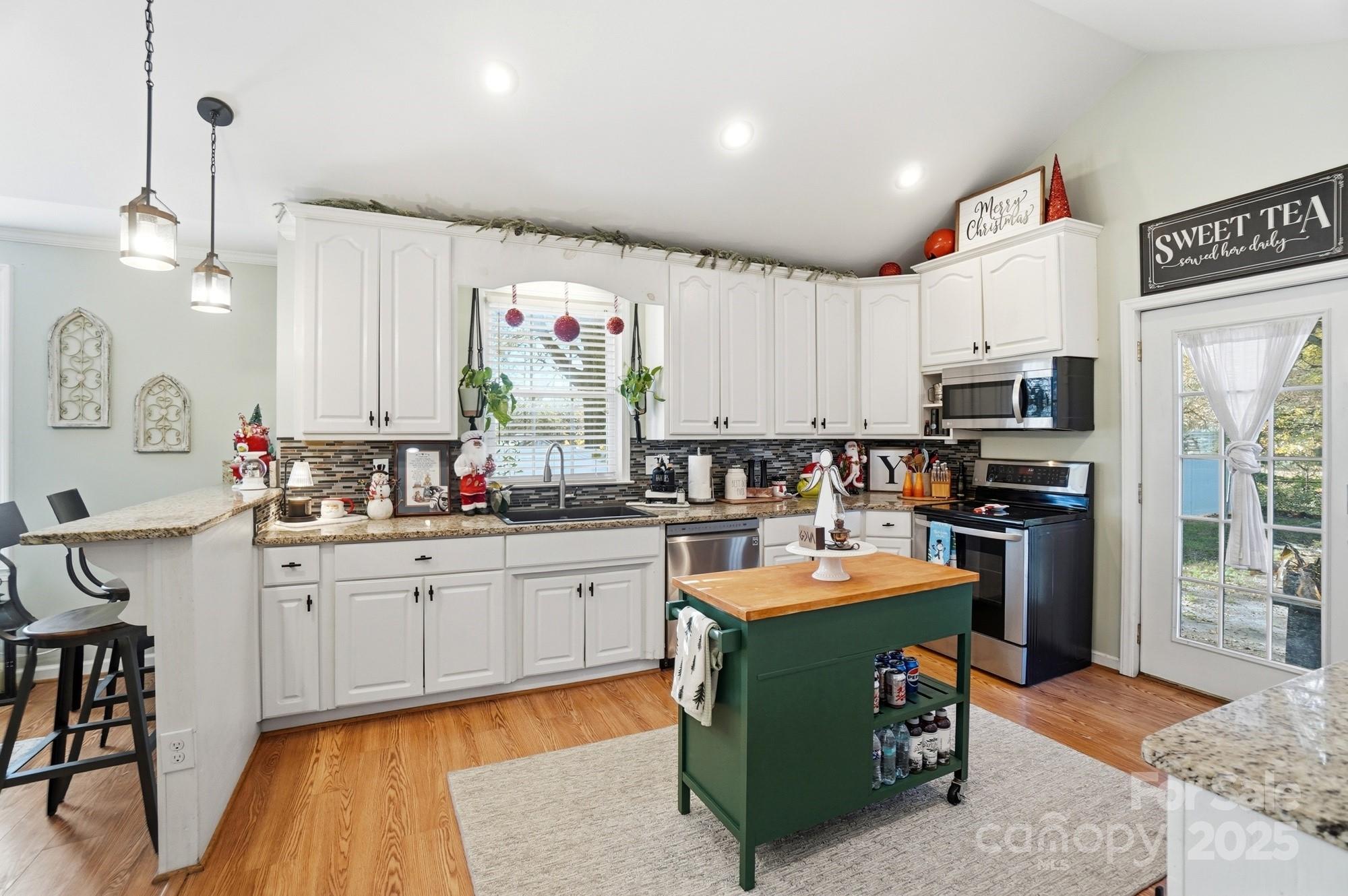 1607 Florida Street Gastonia, NC 28052 - Photo 12 of 24 a kitchen with stainless steel appliances kitchen island granite countertop a sink dishwasher a stove and a refrigerator with wooden floor