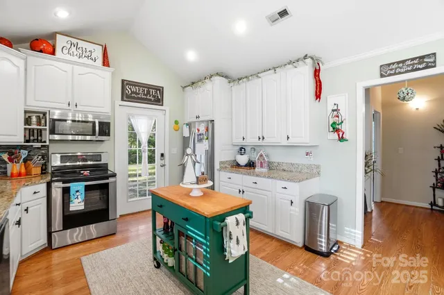 a kitchen with stainless steel appliances a stove refrigerator sink and microwave