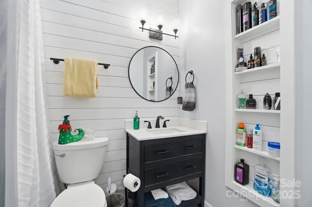 a bathroom with a toilet a sink and a mirror