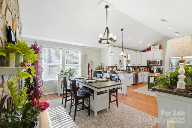 a view of a dining room and livingroom with furniture wooden floor a chandelier