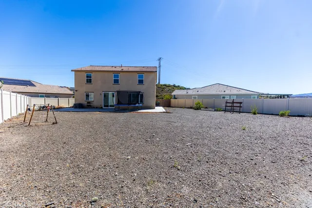 a front view of a house with large trees
