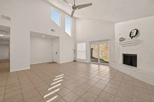 a view of empty room with fireplace and windows