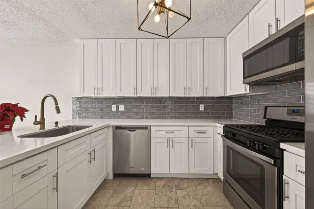 a kitchen with white cabinets and white appliances