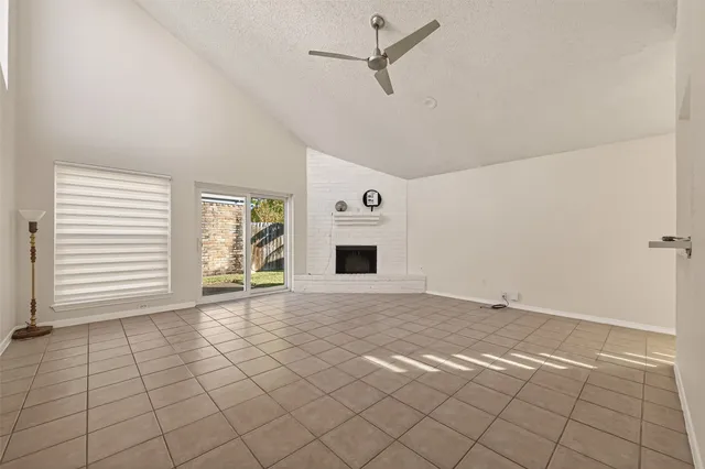 a view of an empty room with a fireplace and a window