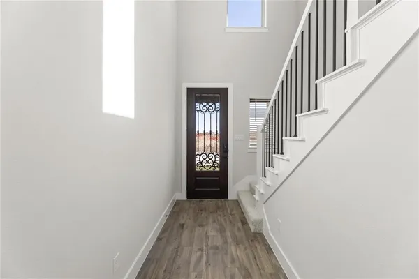 a view of a hallway with wooden floor and entryway