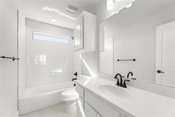 a bathroom with a sink a toilet and a large mirror