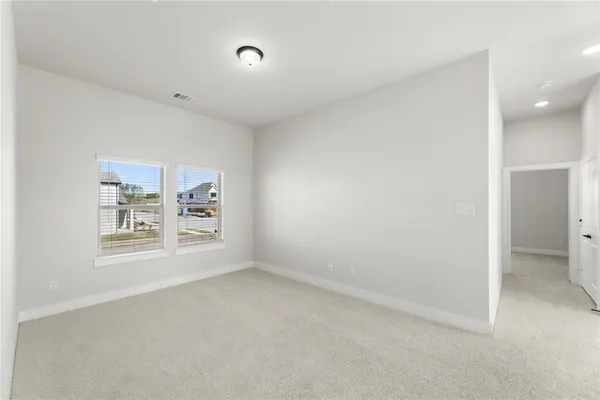 an empty room with a white cabinet and a window