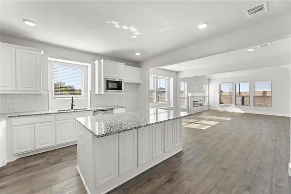 a large white kitchen with granite countertop a large window