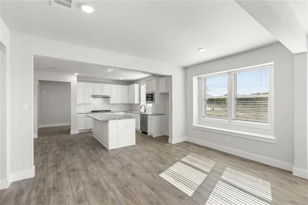 a large kitchen with kitchen island a sink stainless steel appliances and cabinets