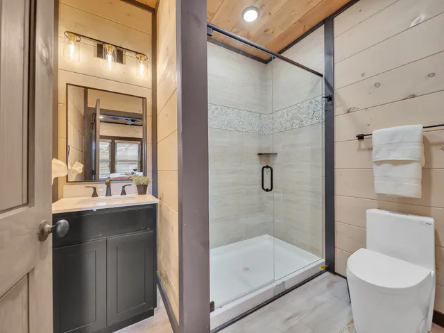 a bathroom with a granite countertop sink toilet and shower