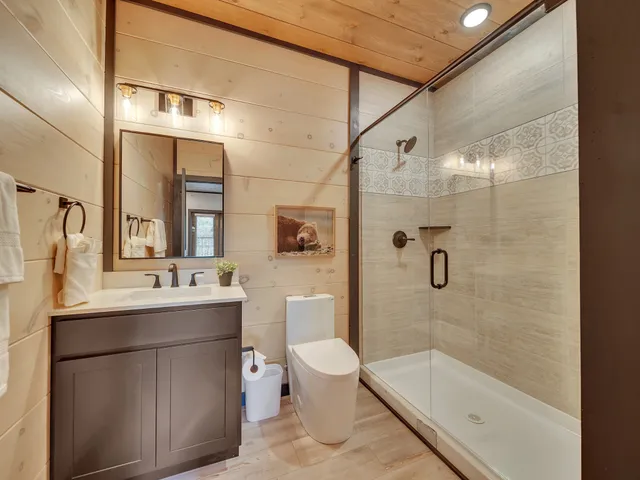 a bathroom with a sink a toilet and shower