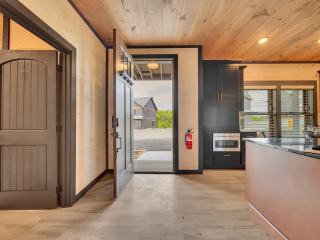 a view of a hallway with wooden floor and windows