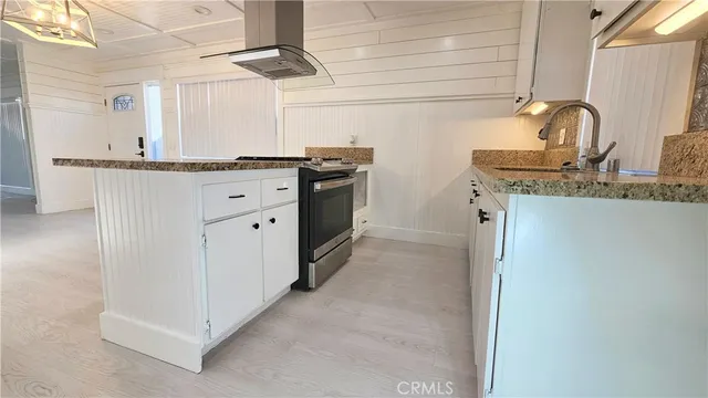 a kitchen with stainless steel appliances granite countertop a sink and a refrigerator