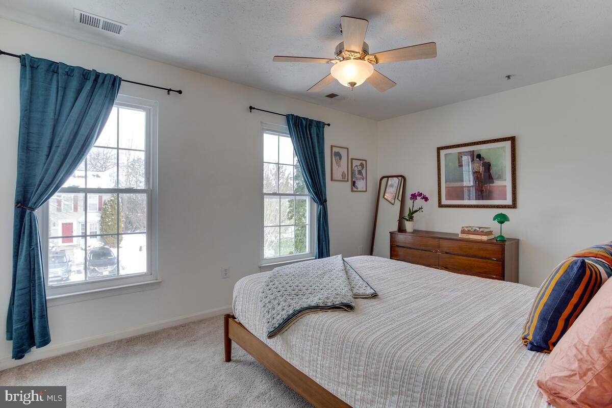 1703 Bluffs Island Court Odenton, MD 21113 - Photo 15 of 38 a bedroom with a large bed a chandelier and a window