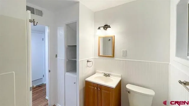 a bathroom with a toilet sink and mirror