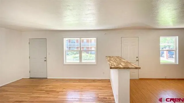 a view of a livingroom with wooden floor and a window
