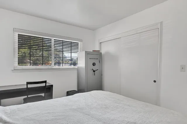 a bedroom with a bed couch and window