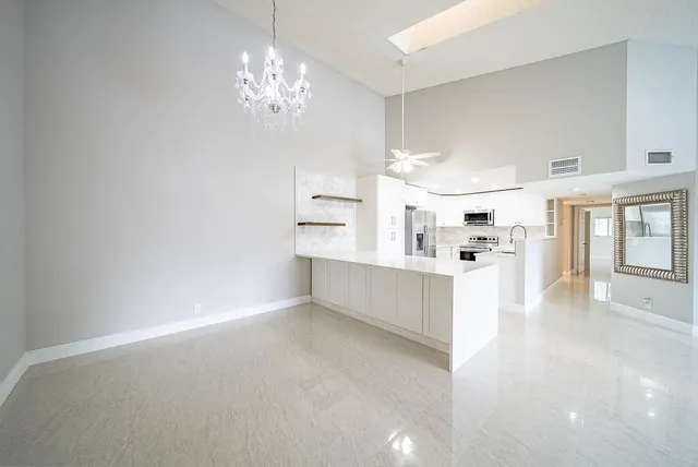 a view of kitchen with cabinets and window