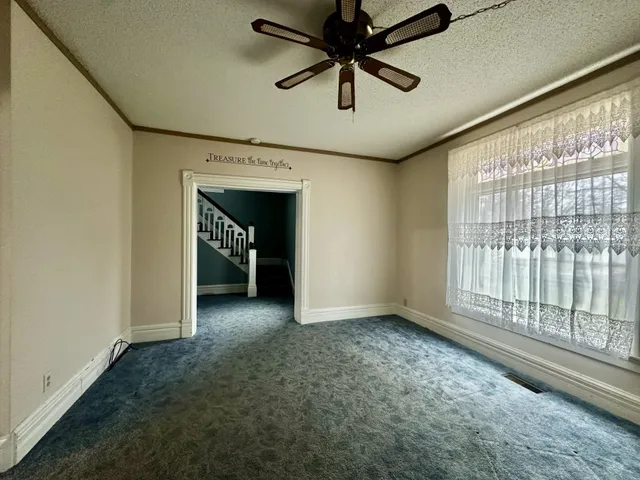 a view of a livingroom with a ceiling fan and window