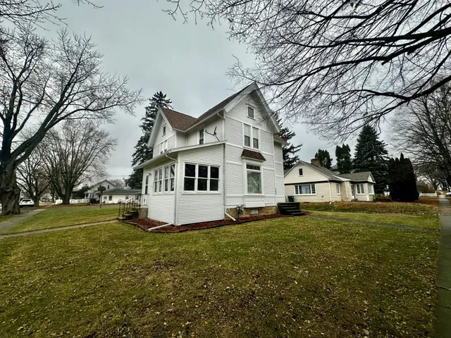 a white house that has a tree in front of it