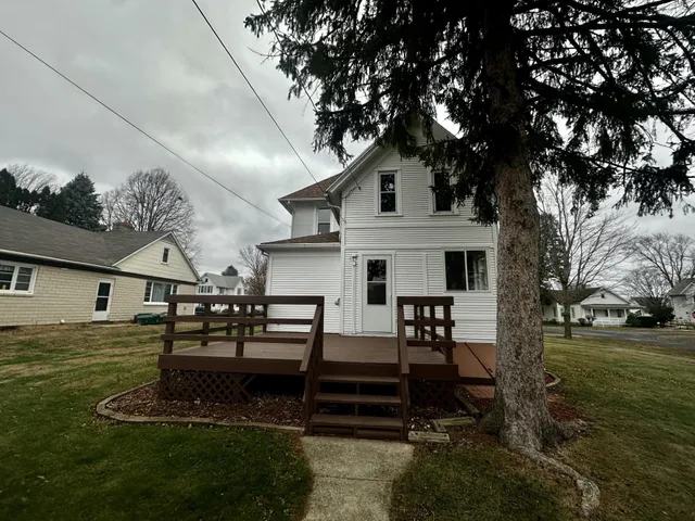 a view of a house with backyard and a tree