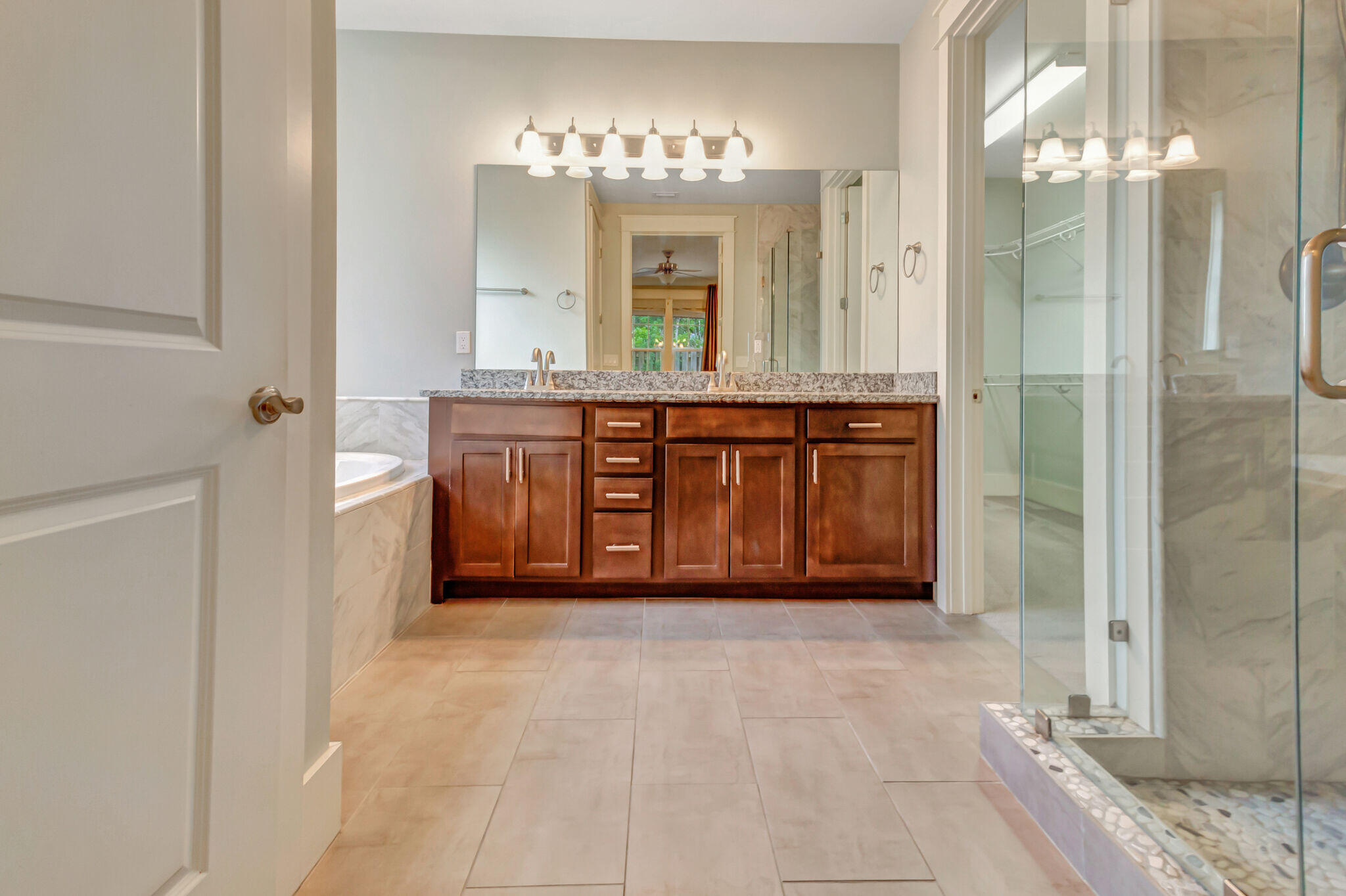 4232 Jade Loop Destin, FL 32541 - Photo 17 of 34 a spacious bathroom with a granite countertop double vanity sink a mirror and a shower
