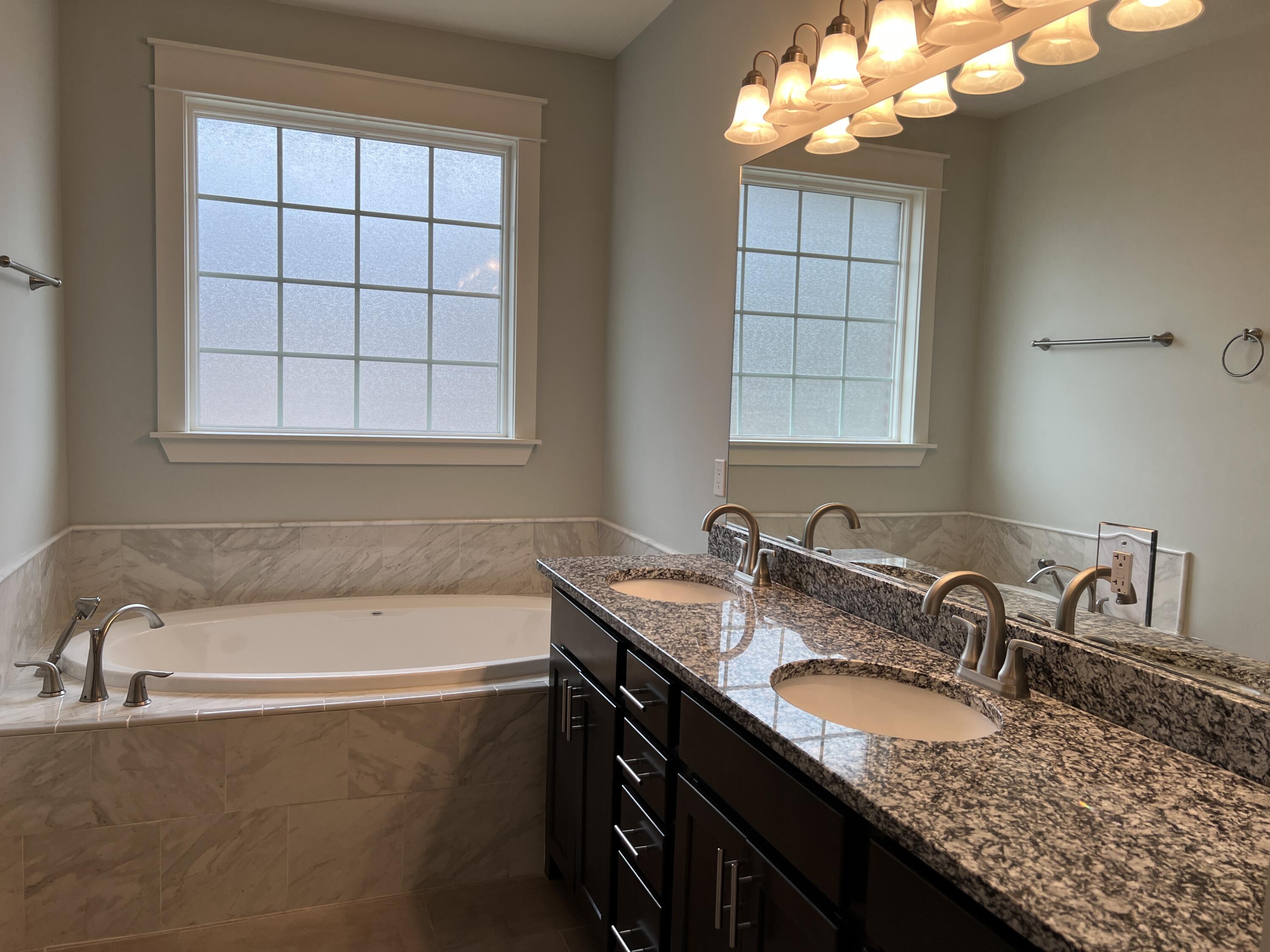 4232 Jade Loop Destin, FL 32541 - Photo 18 of 34 a bathroom with a granite countertop sink and a bathtub