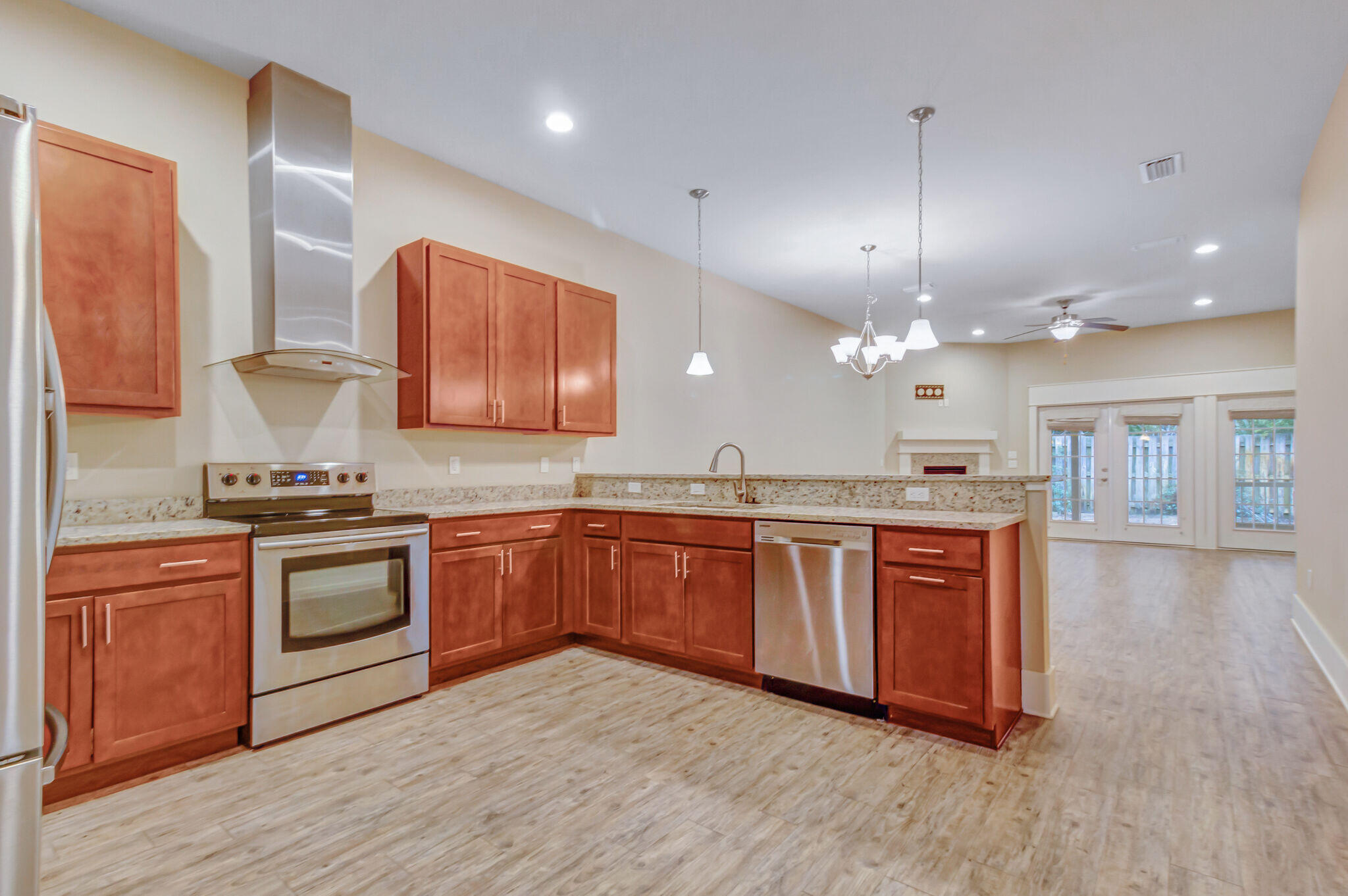 4232 Jade Loop Destin, FL 32541 - Photo 4 of 34 a large kitchen with stainless steel appliances granite countertop a stove a sink dishwasher and a refrigerator with wooden floor