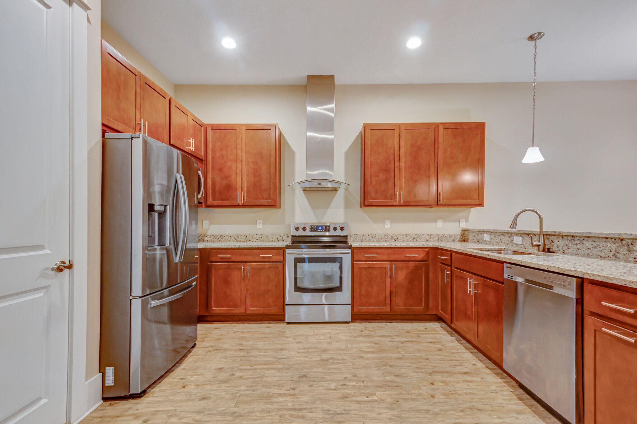 4232 Jade Loop Destin, FL 32541 - Photo 5 of 34 a kitchen with stainless steel appliances granite countertop a refrigerator a sink dishwasher a stove with wooden cabinets and floor