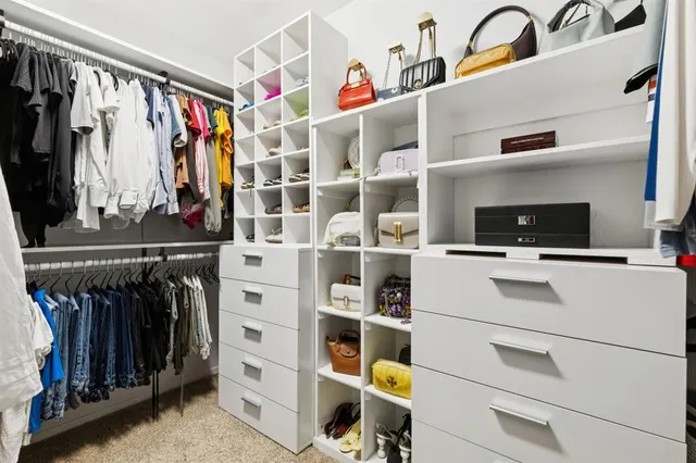 a view of walk in closet with clothes and shoes
