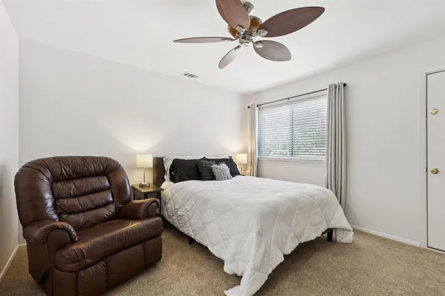 a bedroom with bed couch and window
