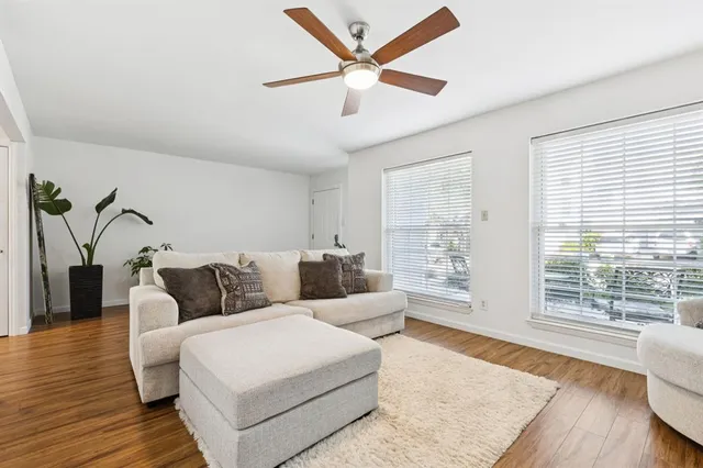 a living room with furniture and a large window with wooden floor
