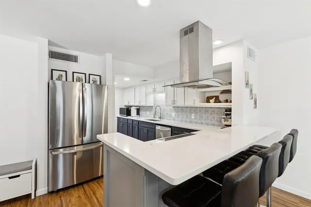 a kitchen with kitchen island a counter and a refrigerator
