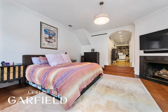 a spacious bedroom with a bed and a television