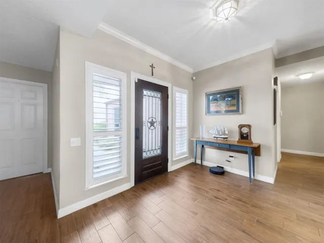 a view of a livingroom with wooden floor and furniture