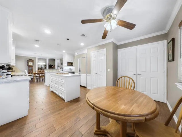 a living room with couches a dining table and chairs with wooden floor