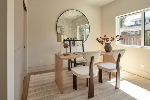 a view of a dining room with furniture and a mirror