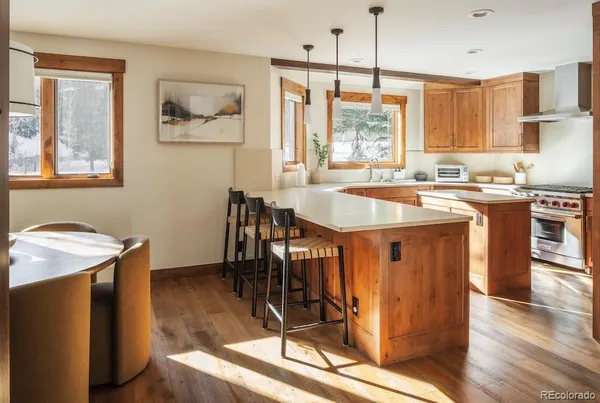 a kitchen with stainless steel appliances granite countertop a stove a sink dishwasher and a refrigerator with wooden floor