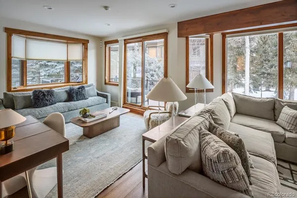 a living room with furniture and floor to ceiling windows