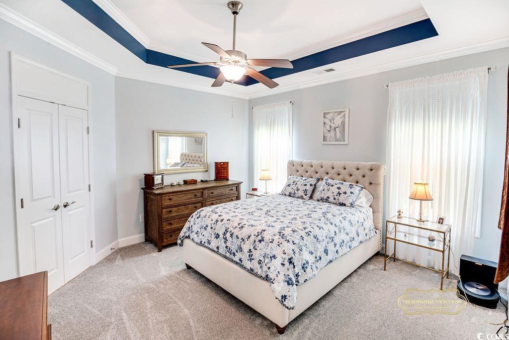 2110 Silver Spring Lane Myrtle Beach, SC 29577 - Photo 12 of 40 Bedroom with a raised ceiling, ornamental molding, light colored carpet, a ceiling fan, and a closet