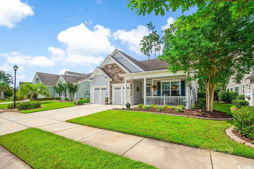 2110 Silver Spring Lane Myrtle Beach, SC 29577 - Photo 2 of 40 Craftsman inspired home featuring covered porch, a front lawn, concrete driveway, stone siding, and a garage